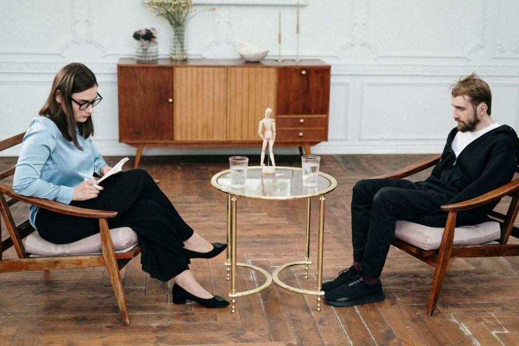 Therapist and client engaged in a counseling session indoors, focused on mental health support.